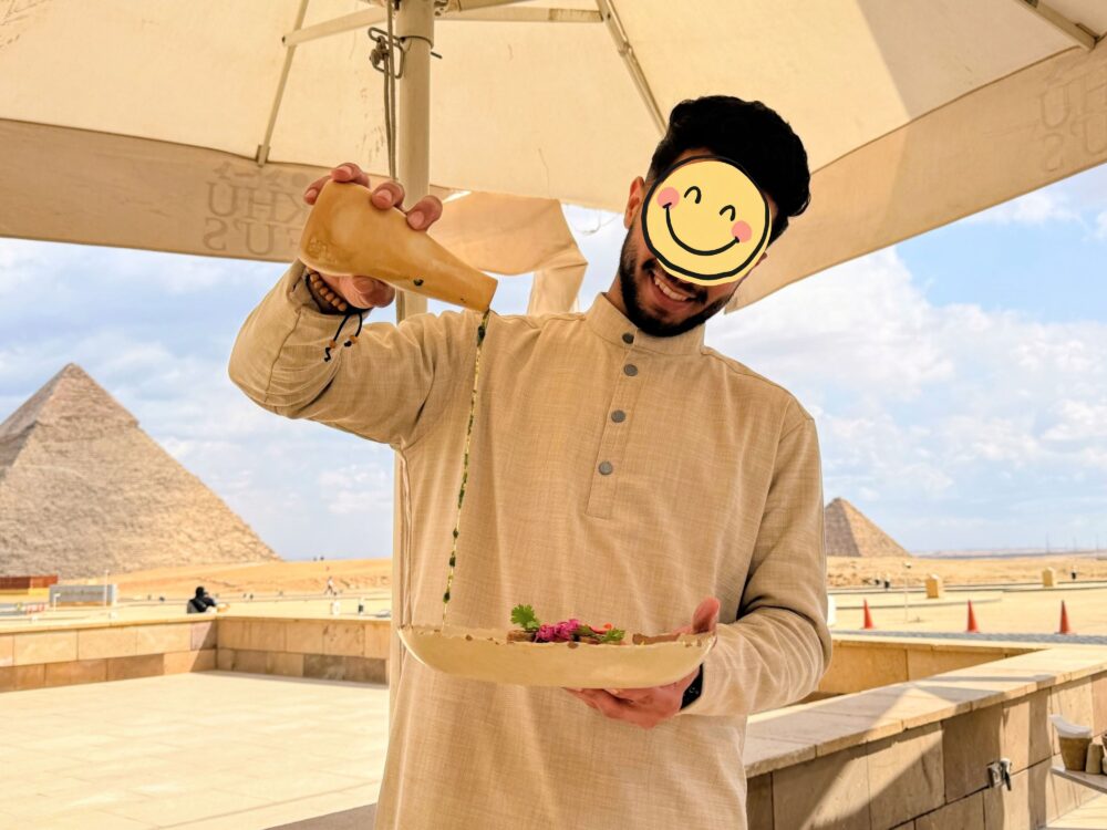 ピラミッドを背景に料理を運ぶKhufu's Restaurantのスタッフ